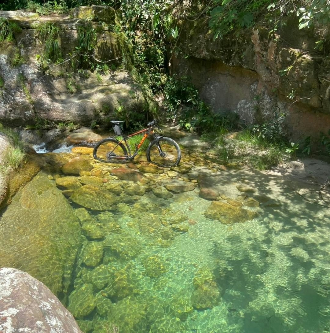 um rio de água cristalina e uma bicicleta bem na beira.