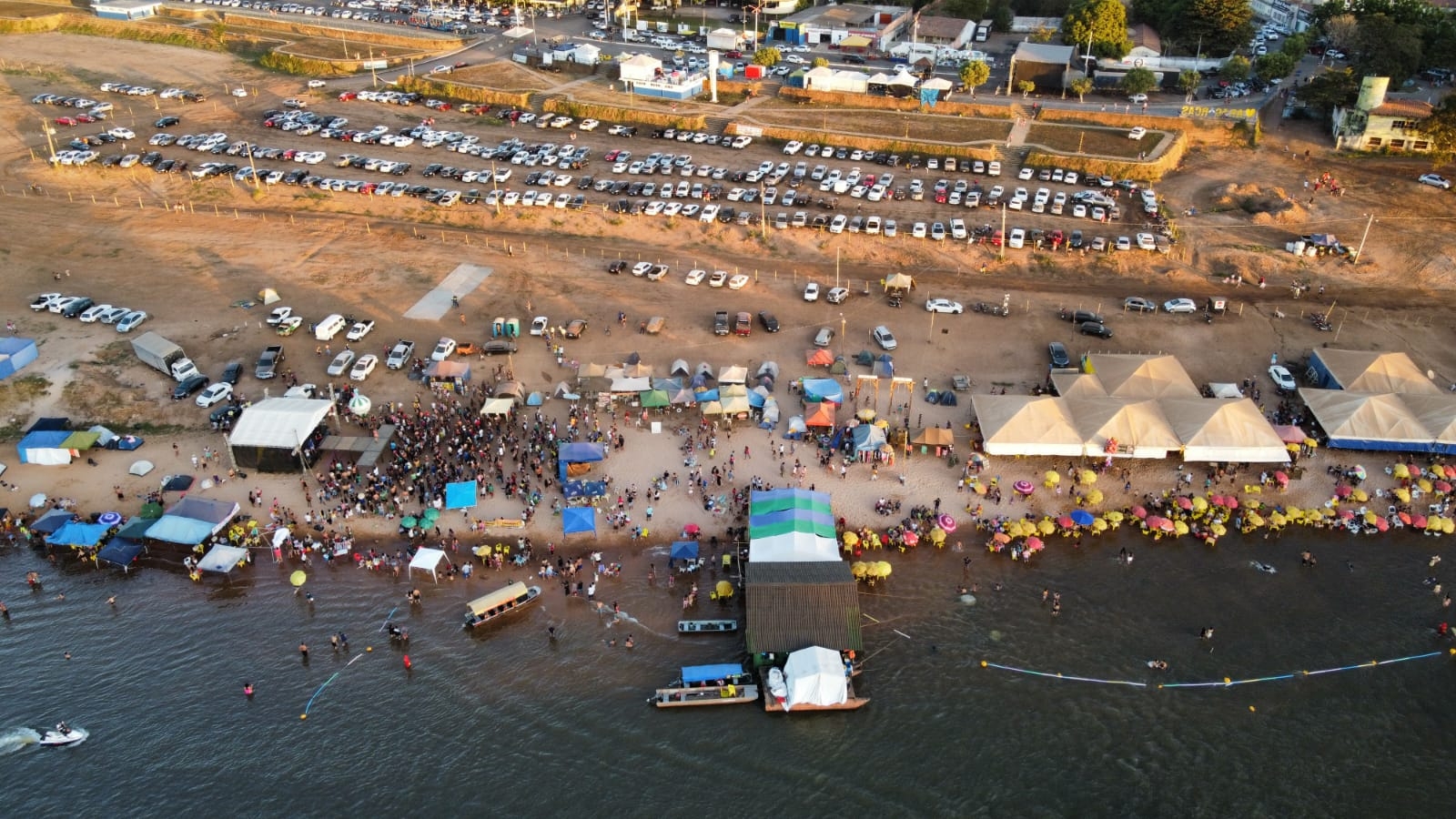 visão aérea da praia quarto crescente com varias tendas e dezenas de pessoas
