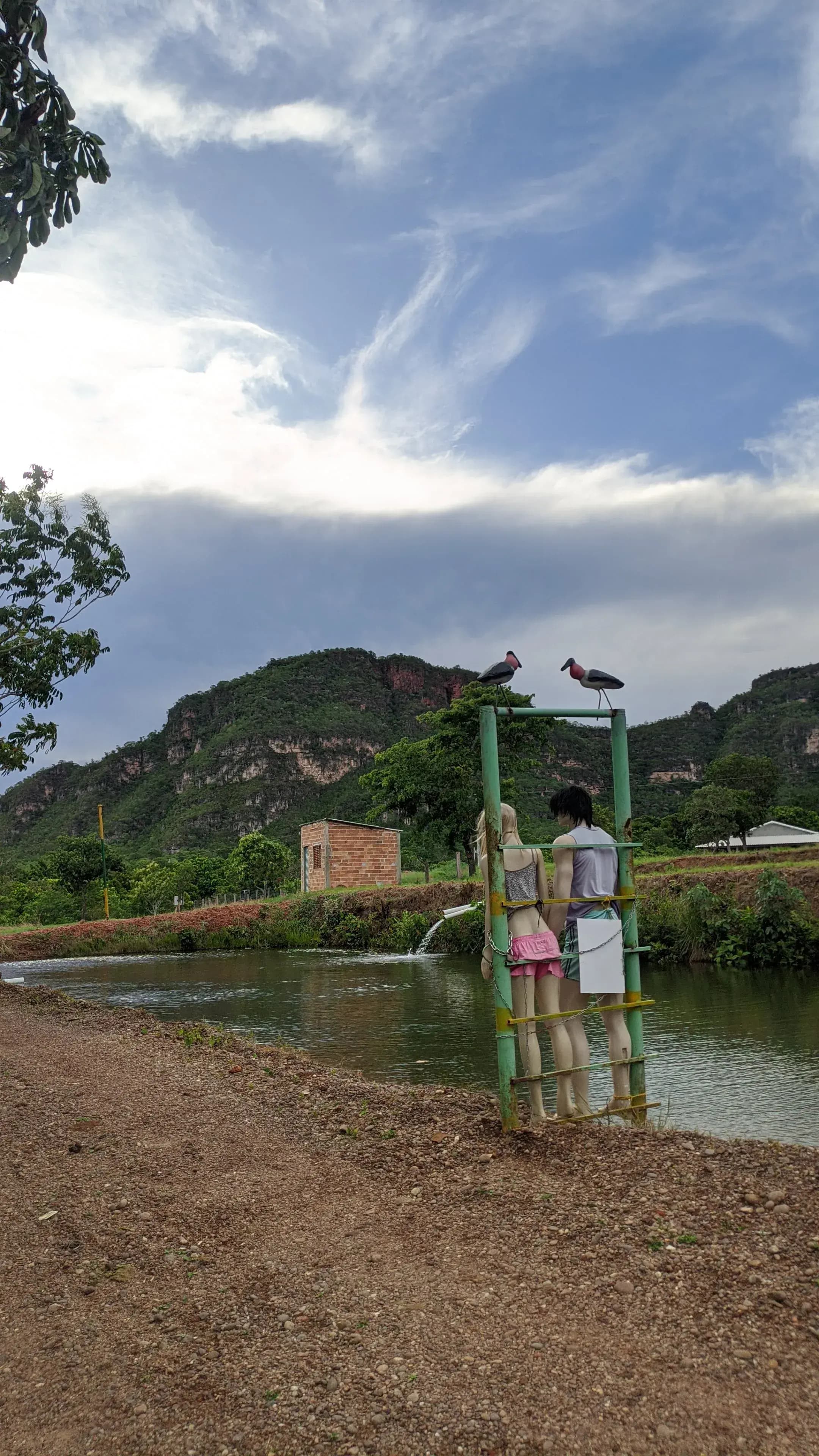 entrada da cachoeira paraiso com a vista da serra e dois manequins parados