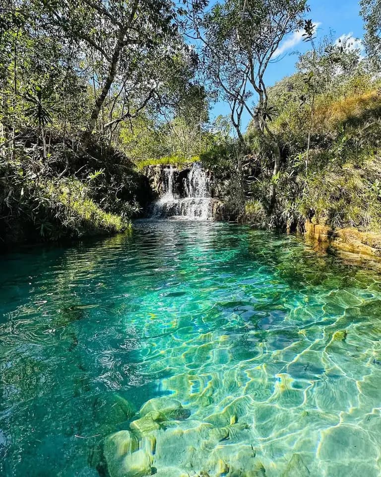 água cristalina com tom esverdeada e uma pequena queda de mais ou menos 1.5m de altura
