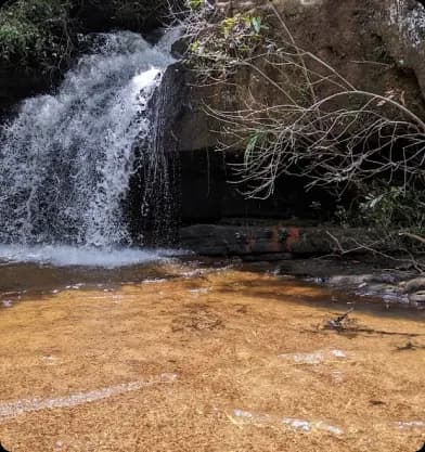 Cachoeira com pequena queda d'água e grande volume, parte da Trilha das Cachoeiras.